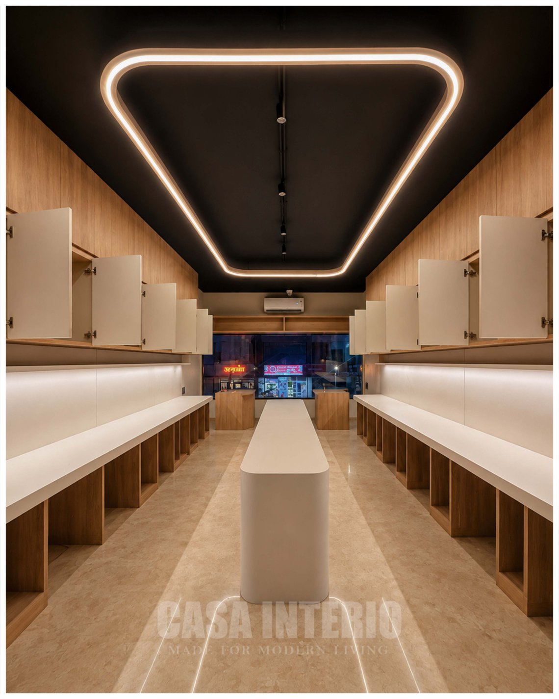 Long workstation bay with oak joinery, lit counters and a loop ceiling light