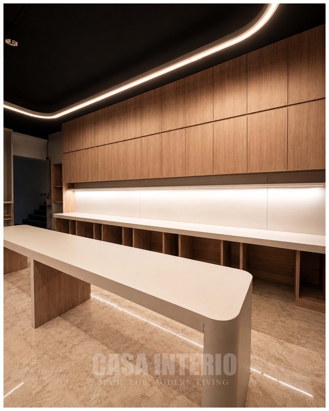 Bench desks below a run of oak overhead storage and cove lighting