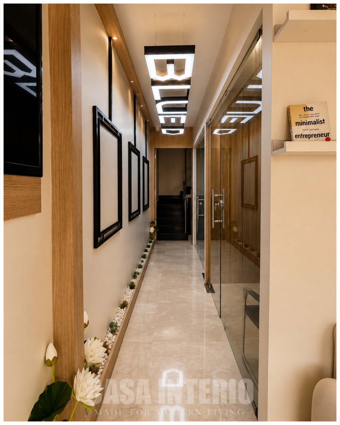 Entry corridor with framed art, glass cabins and backlit ceiling signage