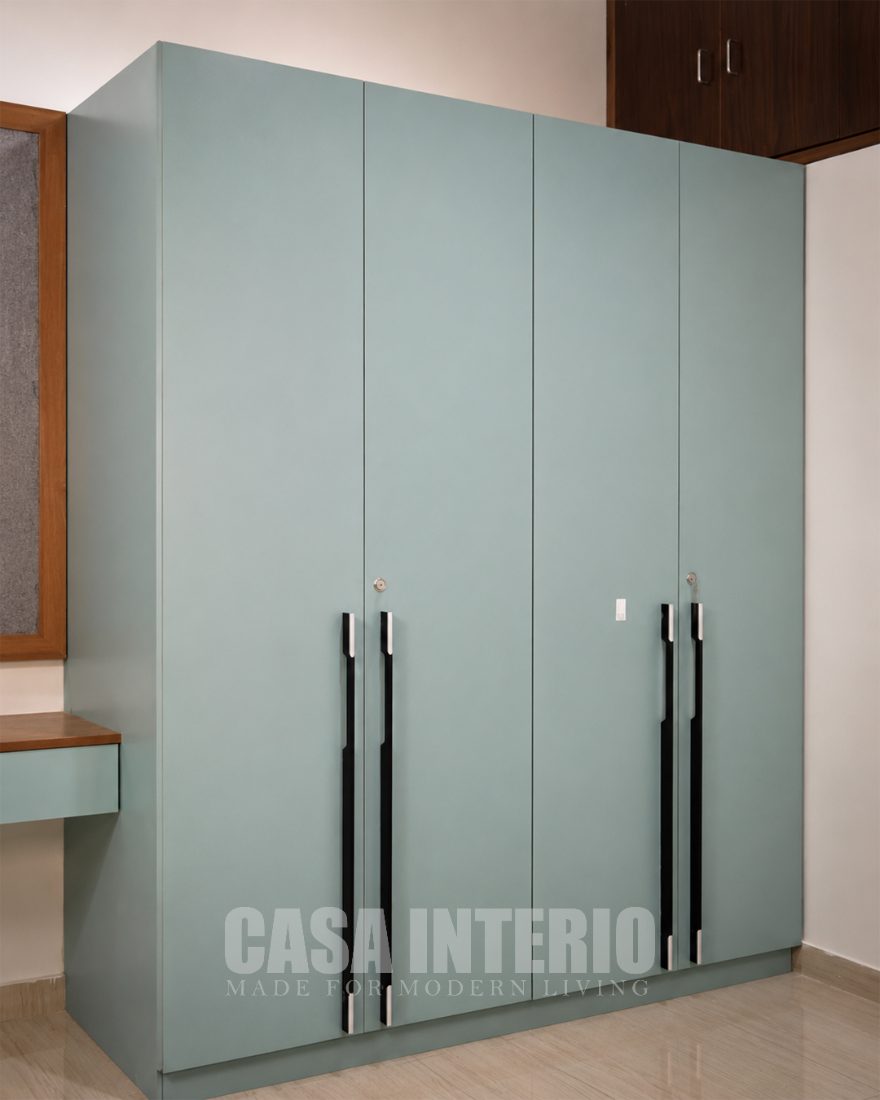 Sage green four-door wardrobe with slim handles